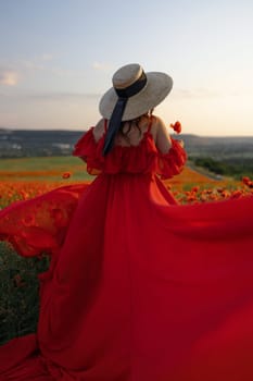 Woman poppy field red dress hat. Happy woman in a long red dress in a beautiful large poppy field. Blond stands with her back posing on a large field of red poppies