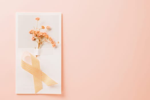 Pink awareness ribbon sign and paper card flower of World Cancer Day on pink background with copy space, concept of medical and health care support, Breast cancer awareness concept, 4 February