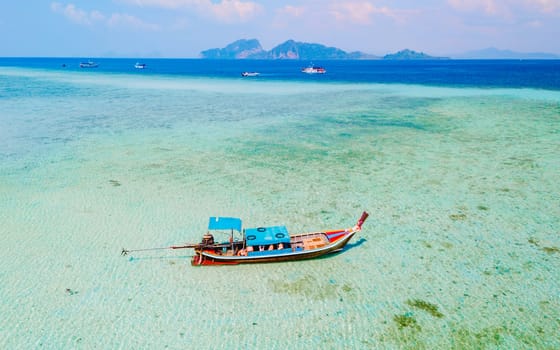 longtail boat in the turqouse colored ocean with clear blue green crystal water at Koh Kradan a tropical island in Trang Thailand