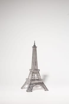 Metal Eiffel Tower cutout on white background. Lattice design highlights skill and precision, creating intricate pattern.