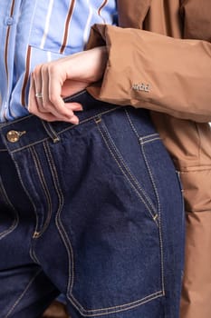 Close-up shot of a stylish woman in blue jeans, highlighting her hands in the pockets, ideal for showcasing urban streetwear fashion.