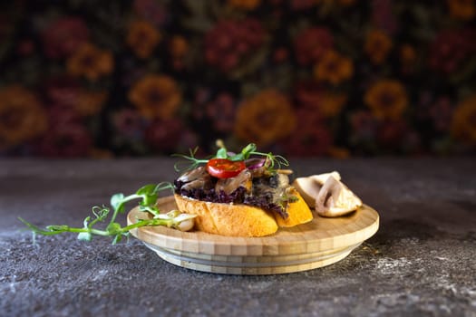 Rustic wooden plate with open faced sandwich with beef tenderloin and roasted mushrooms, garnished with fresh sprouts.