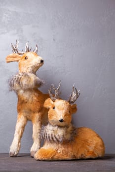 Adorable reindeer figurines with silver antlers, perfect for holiday displays, isolated on gray. Add a festive touch