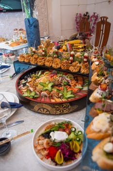 An opulent buffet showcasing a lavish assortment of fresh seafood, sushi, salads, fruits, and pastries, beautifully arranged on a pristine white tablecloth for a luxurious and celebratory event.