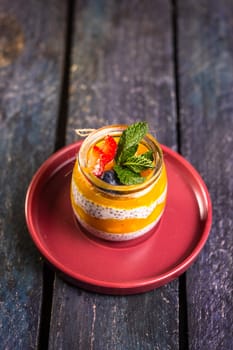 Chia seed pudding with mango, mixed berries, milk, Greek yogurt, assorted fruit, and honey. Tropical-inspired delight for a refreshing summer treat.