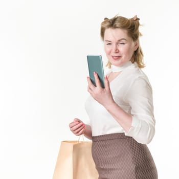 Happy shopaholic women using mobile phone for making payment. Black Friday and shopping online concept. 49 years old smiling woman shopper in white blouse and brown skirt on white background