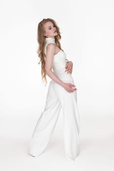 Back view of young woman looking over shoulder at down wearing white long jumpsuit sleeveless standing in full length. Elegance fashion model with long blonde hair. Studio shot on white background