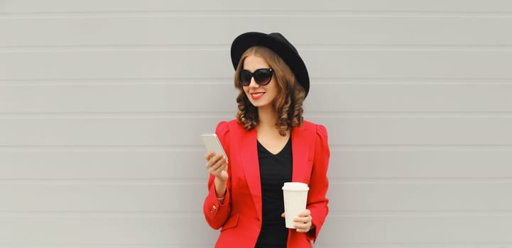 Beautiful stylish lady woman with smartphone in red blazer business jacket, black round hat