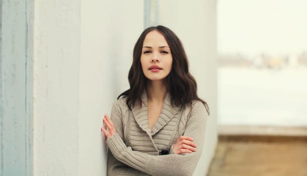 Portrait of beautiful caucasian brunette young woman posing on city street