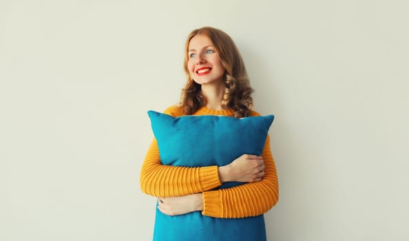 Healthy sleep, happy young woman hugs her soft comfortable pillow imagining that she is lying on the bed