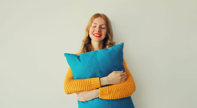 Healthy sleep, happy young woman hugs her soft comfortable pillow imagining that she is lying on the bed