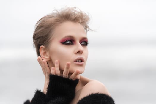 Portrait blonde woman fashion model looking away, posing outdoors on white natural background. Face of Caucasian woman with short hair, bright makeup. Soft selective focus adds to overall dreamy vibe