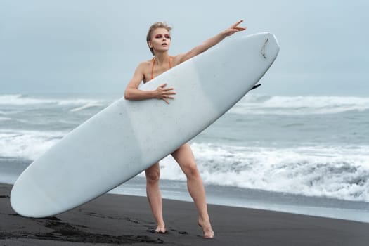 Female holding surfboard and striking relaxed pose that just screams summer vacation. Her confident gaze fixed away, epitome of active lifestyle. Woman surfer is perfect embodiment of sports concept