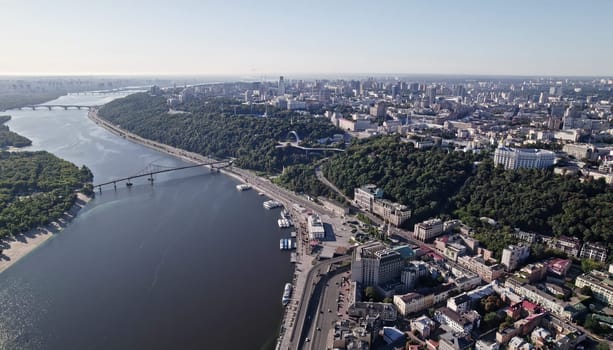 Kyiv, Ukraine - April, 2023: aerial drone view to Dnieper river near Podil. Flight over capital - one of greenest metropolis in Europe. Ecology, nature concept. High quality photo