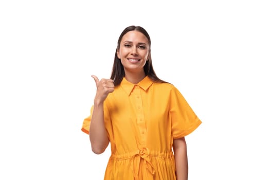 pretty young brunette lady dressed in a bright yellow short sleeve dress attracts attention and wants to tell the news.