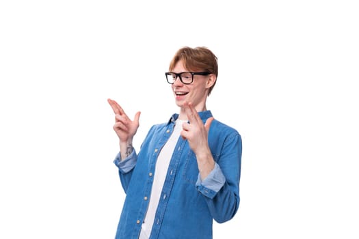 young cheerful red-haired guy dressed in a blue shirt over a t-shirt.