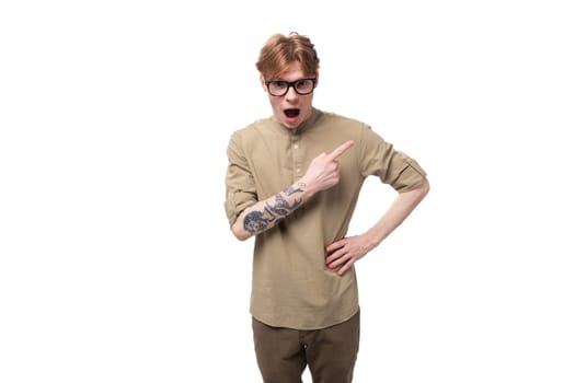 young shocked surprised redhead caucasian guy dressed in khaki short sleeve shirt.