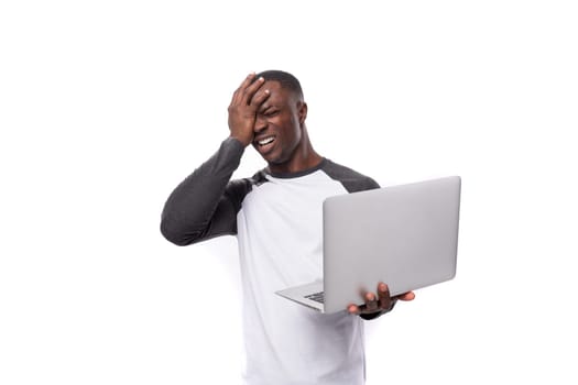 young african man working remotely in IT field and holding nuotbook on white background.