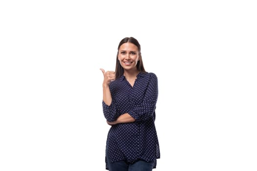 young european slender brunette woman in blue clothes points her hand to the side. advertising concept.