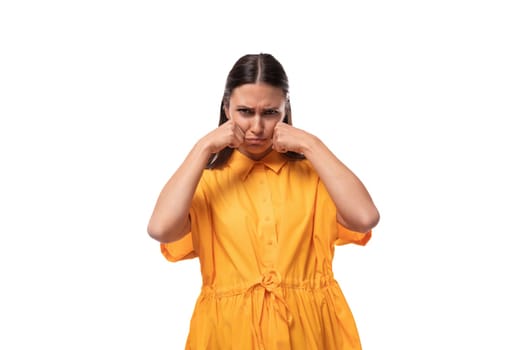 pretty young brunette lady dressed in a bright yellow short sleeve dress upset and offended.