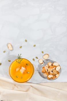 Pumpkin cream soup with crackers and seeds, top view, with copy space. Vegetarian lunch