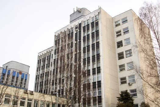 Windows of a multi-storey tall building against the background of the sky