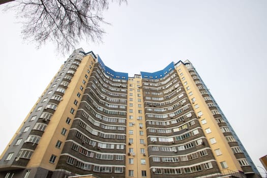 Windows of a multi-storey tall building against the background of the sky