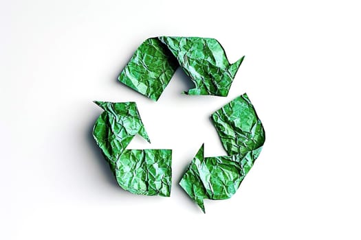 Recycling symbol made of crumpled green paper on a white background. Environmental protection concept.