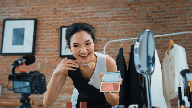 Woman influencer shoot live streaming vlog video review vivancy makeup social media or blog. Happy young girl with cosmetics studio lighting for marketing recording session broadcasting online.