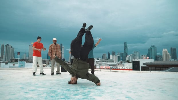 Hispanic hipster dancing surrounded by multicultural friend at city view with blue sky. Group of street dancer performing at rooftop. Active, fun, happy atmosphere. Outdoor sport 2024. Endeavor.