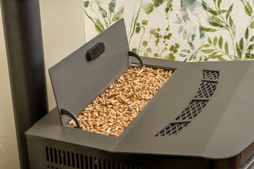 Horizontal image of a pellet stove with a full hopper, sustainable heat. Green energy concept