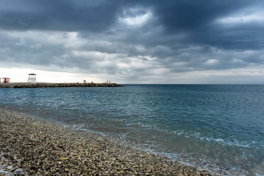 Scenic landscape of the beach and dark blue sea, cloudy sky before a thunderstorm. A bay in the resort village of Nebug, Krasnodar Territory.