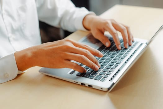 Businessman hand typing on computer keyboard of a laptop computer in office. Business and finance concept. uds