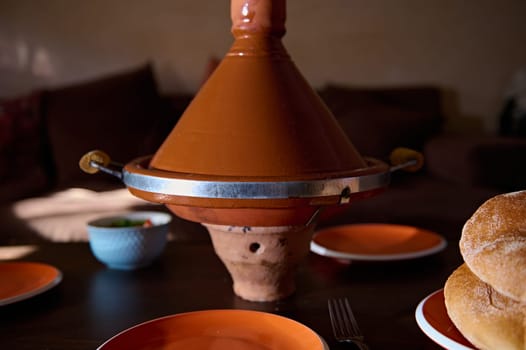 Traditional Moroccan Tagine - a meal of steamed veggies or meat in clay pot, served at home. Culinary. Cuisine. Culture and traditions of Morocco