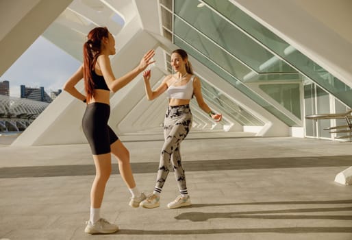 Sporty women greeting together outdoor doing gesture of shake hand after exercising