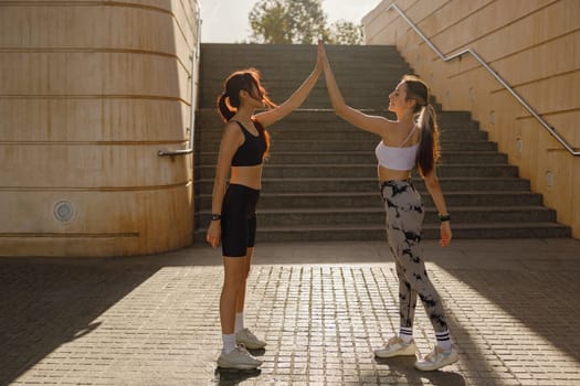 Sporty women greeting together outdoor doing gesture of shake hand after exercising