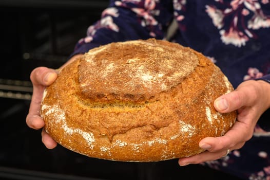 appetizing homemade whole grain bread in the hands of a woman 10