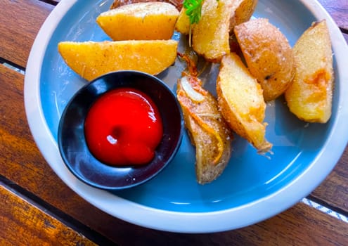 Top View Baked potato wedges with shredded onion and herbs and tomato sauce platted homemade organic vegetable vegan vegetarian potato wedges snack food meal