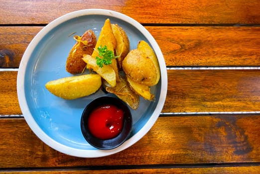 Top View Baked potato wedges with shredded onion and herbs and tomato sauce platted homemade organic vegetable vegan vegetarian potato wedges snack food meal