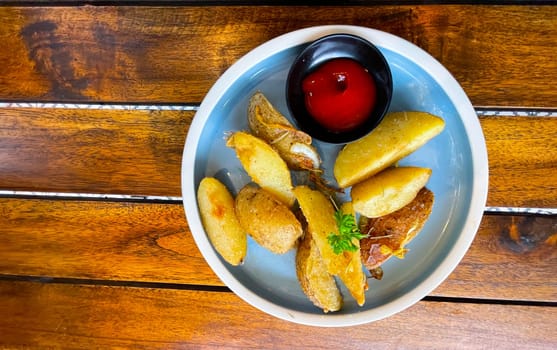 Top View Baked potato wedges with shredded onion and herbs and tomato sauce platted homemade organic vegetable vegan vegetarian potato wedges snack food meal