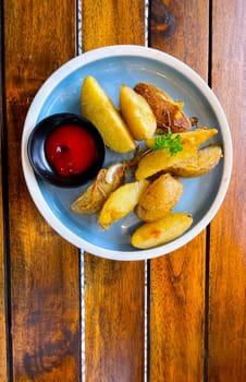 Top View Baked potato wedges with shredded onion and herbs and tomato sauce platted homemade organic vegetable vegan vegetarian potato wedges snack food meal