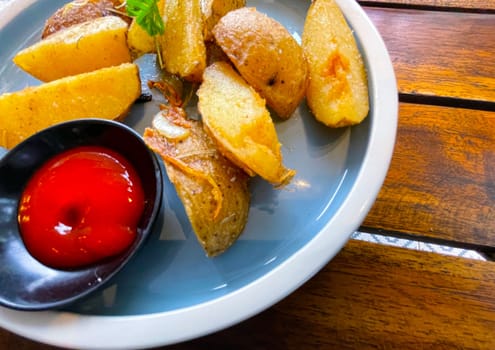 Top View Baked potato wedges with shredded onion and herbs and tomato sauce platted homemade organic vegetable vegan vegetarian potato wedges snack food meal