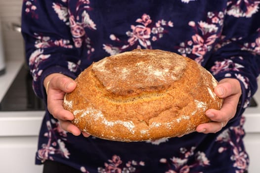 appetizing homemade whole grain bread in the hands of a woman 2