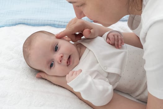 Mom plays with newborn baby and baby is happy.