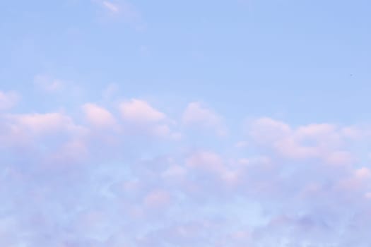 Background of blue sky with pale pink clouds in sunset