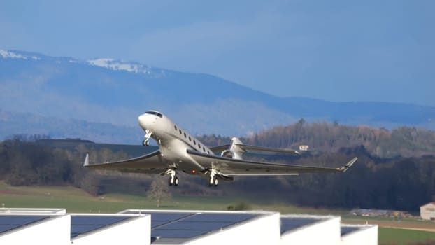 Payerne Switzerland January 15, 2024: Corporate Jet Take Off in Blue Sky in Alpine Scenario with Copy Space. Gulfstream 650 OE-LTF