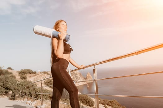 Fitness woman sea. Outdoor workout on yoga mat in park near to ocean beach. Female fitness pilates yoga routine concept. Healthy lifestyle. Happy fit woman exercising with rubber band in park.