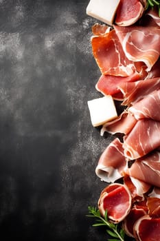 Assorted cured meats arranged elegantly with herbs on dark backdrop.