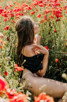 Woman poppies field. portrait of a happy woman with long hair in a poppy field and enjoying the beauty of nature in a warm summer day