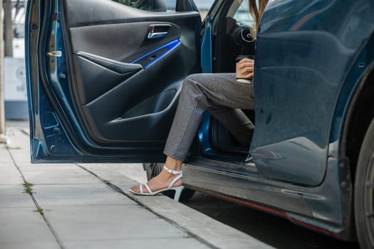 In a city setting a businesswoman in a stylish suit sits in a luxury car. Her slender leg clad in high heels gracefully opens door showcasing the blend of modern transportation and corporate glamour.